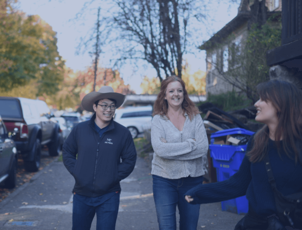 Three APM Help team members chatting and laughing together outside